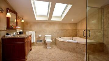 A modern bathroom with skylights, a freestanding bathtub, and a glass-enclosed shower.