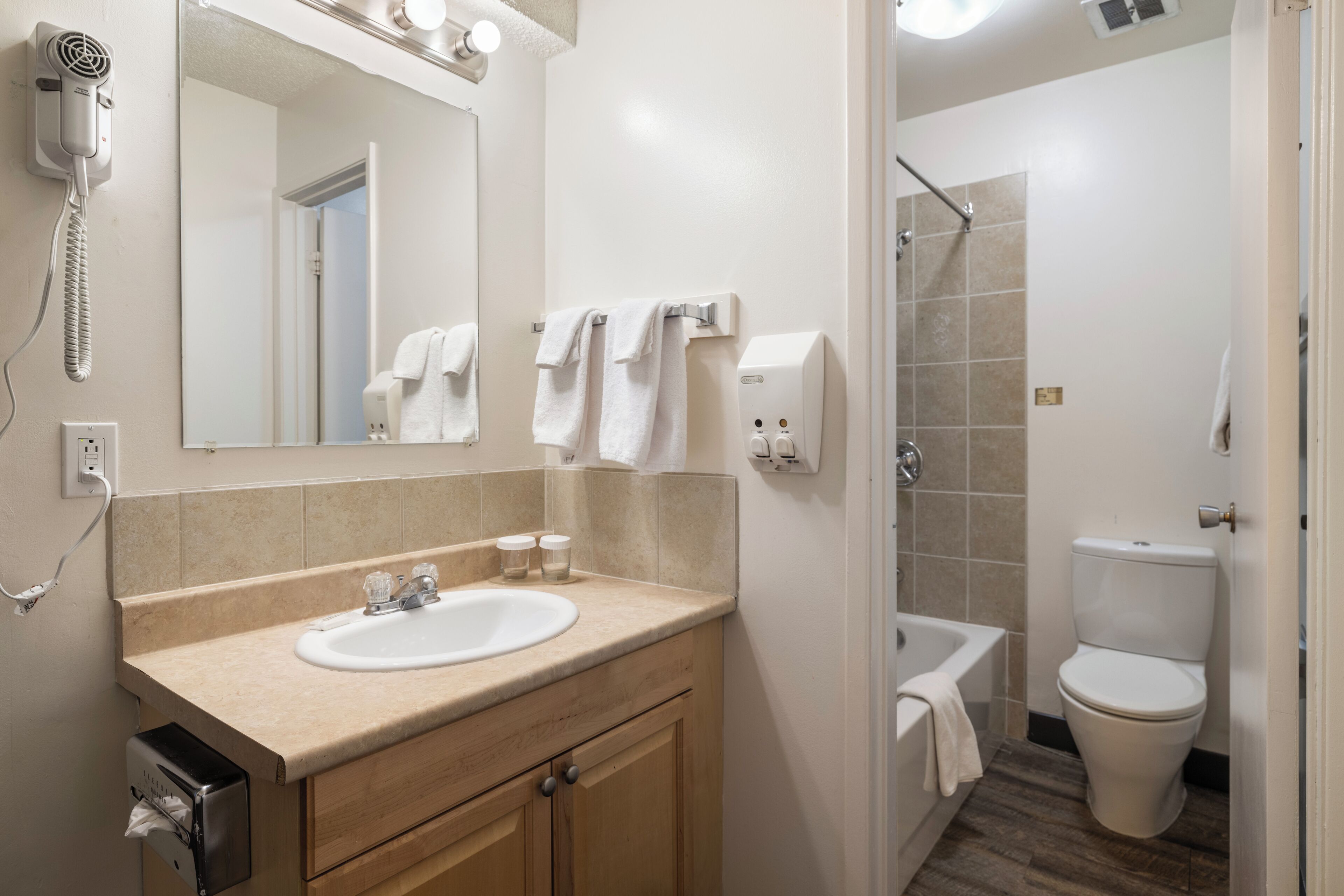 A bathroom with a sink, mirror, towel rack, and a toilet.