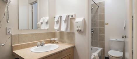A bathroom with a sink, mirror, towel rack, and a toilet.