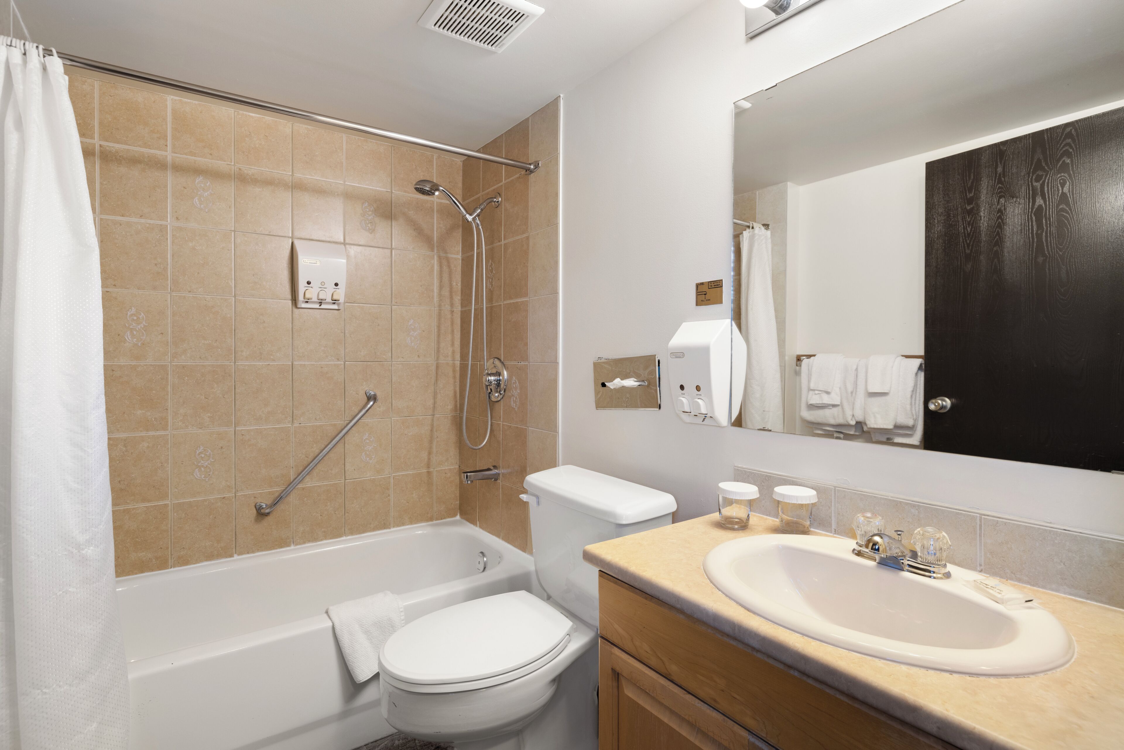 A bathroom with a bathtub, toilet, and sink.