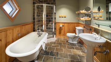 A bathroom with a freestanding bathtub, a glass-enclosed shower, a toilet, and a pedestal sink.