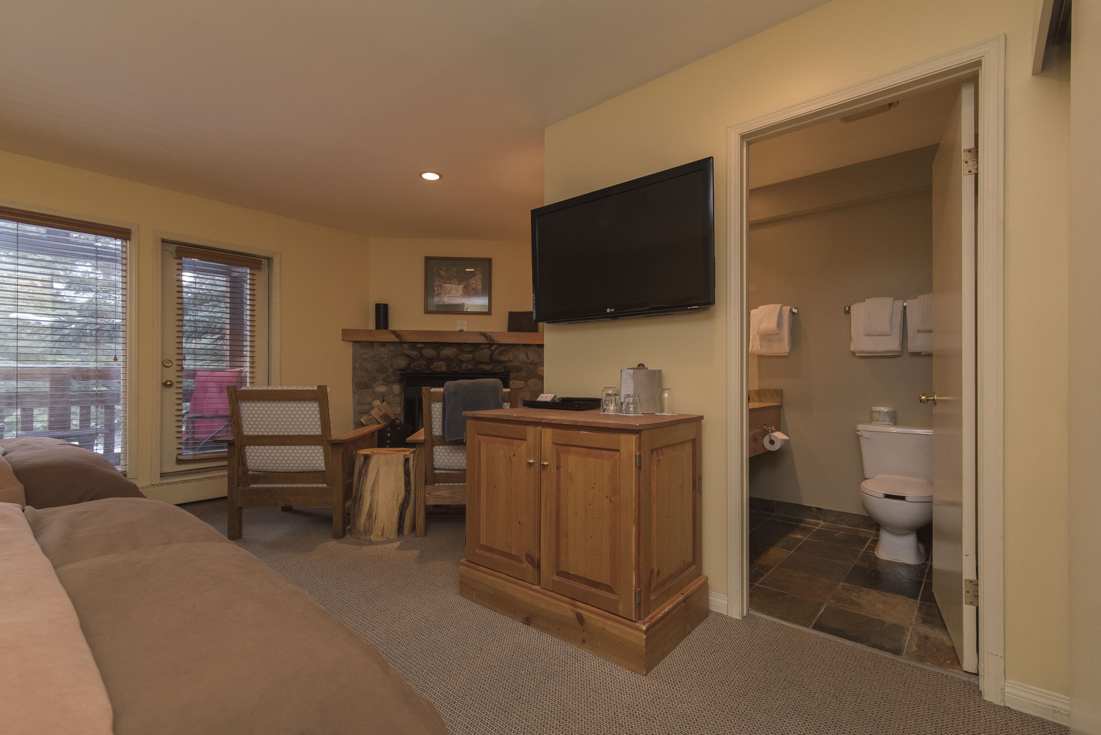 A living room with a sofa, wooden cabinet, and a flat-screen TV mounted on the wall.