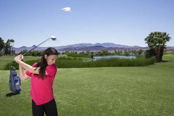 A golf course with a clear view of the mountains in the background.