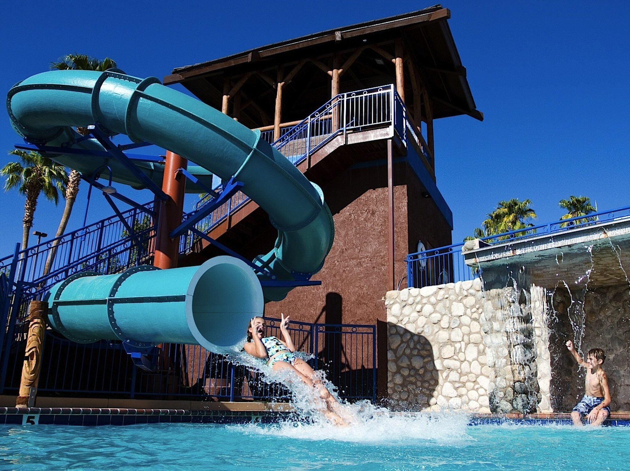 Un parc aquatique doté de deux grandes toboggans et d’un espace piscine.