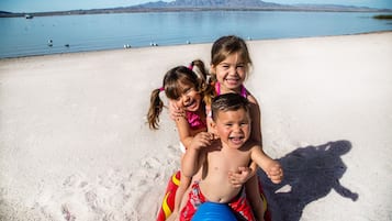 En la playa, vóleibol de playa y kayaks