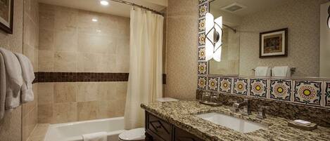 A bathroom with a bathtub, toilet, and sink.