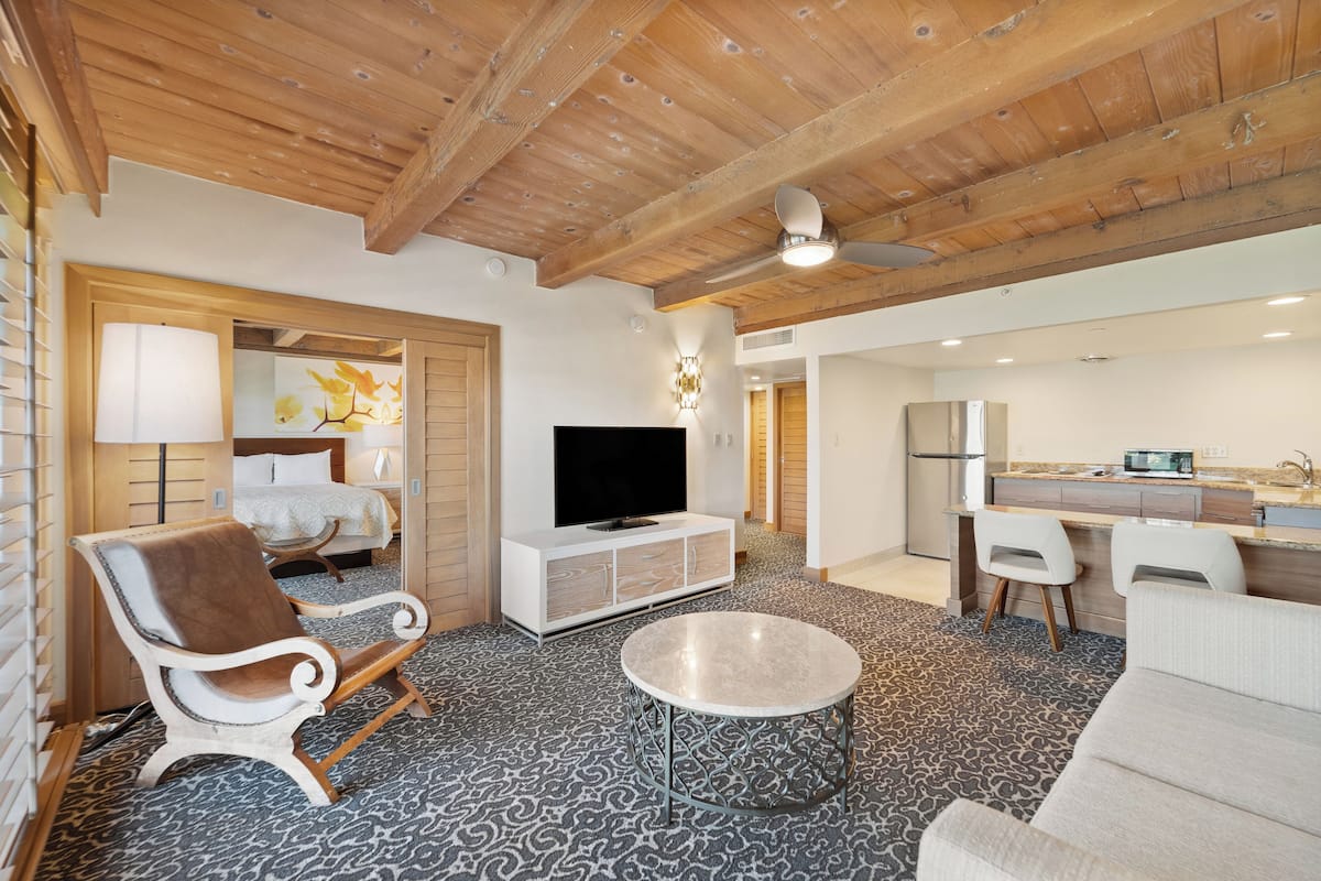 Un salon moderne avec un canapé, une table basse, un téléviseur et une cheminée.