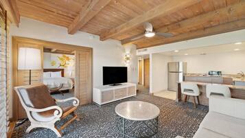A modern living room with a sofa, a coffee table, a TV, and a fireplace.