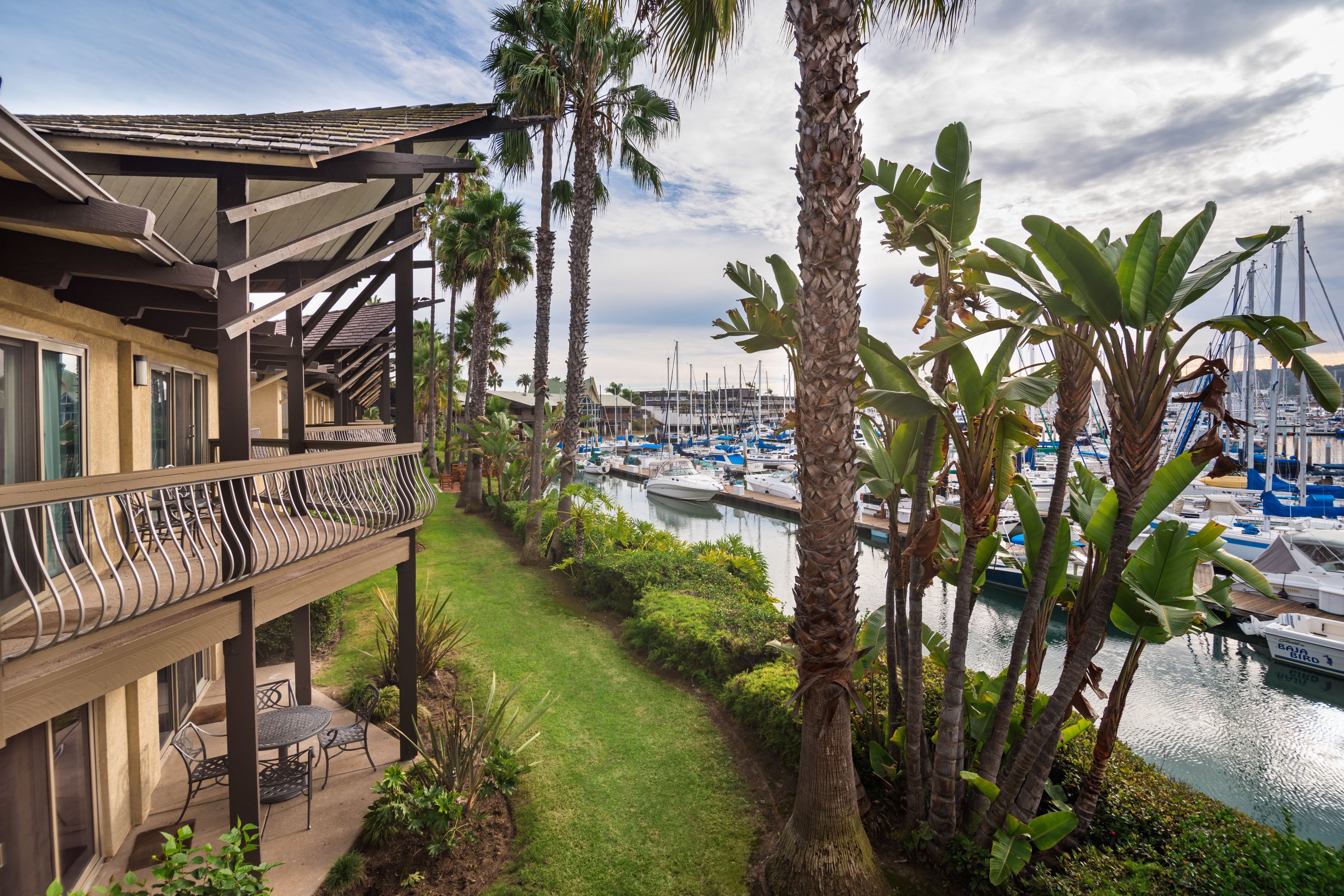 A balcony with outdoor furniture overlooking a marina with boats.