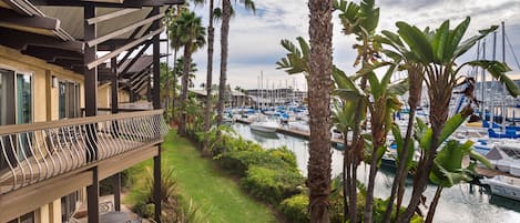 A balcony with outdoor furniture overlooking a marina with boats.