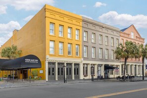 A hotel with a yellow facade, a black awning, and a sign reading 'Lodge Alley Inn.' - Hilton Vacation Club Lodge Alley Inn Charleston (Charleston)