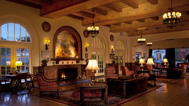 A spacious lobby with a fireplace, comfortable seating, and elegant chandeliers. - Hassayampa Inn (Prescott)