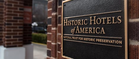 A sign for Historic Hotels of America, National Trust for Historic Preservation, mounted on a brick wall.