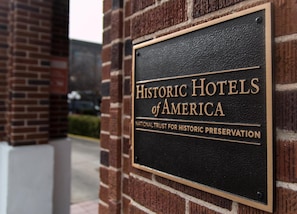 A sign for Historic Hotels of America, National Trust for Historic Preservation, mounted on a brick wall.