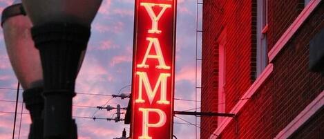 A neon sign for Hassayampa Inn against a sunset sky.