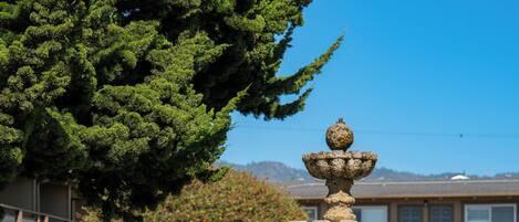 Una fuente de piedra en un patio con un edificio al fondo.
