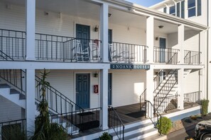 NOANK HOUSE features a two-story exterior with a balcony and a charming garden.