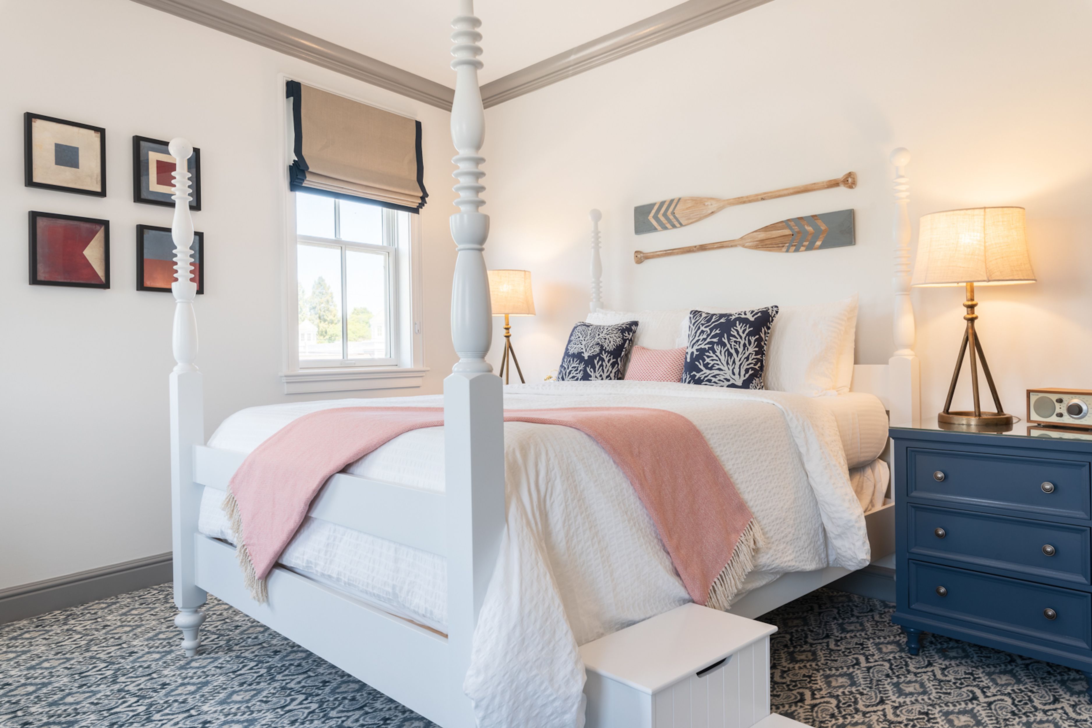Een slaapkamer met een hemelbed, een kaptafel en een raam met uitzicht.