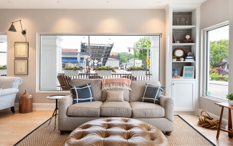 A living room with a large window, a sofa, a coffee table, and a rug.