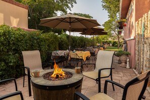 Enjoy al fresco dining and relaxation in this serene outdoor space, featuring a fire pit and comfortable seating.
