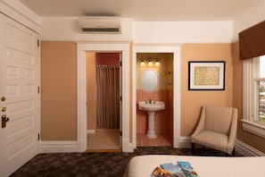 Relax in a stylish room with a comfortable bed, armchair, and modern amenities.