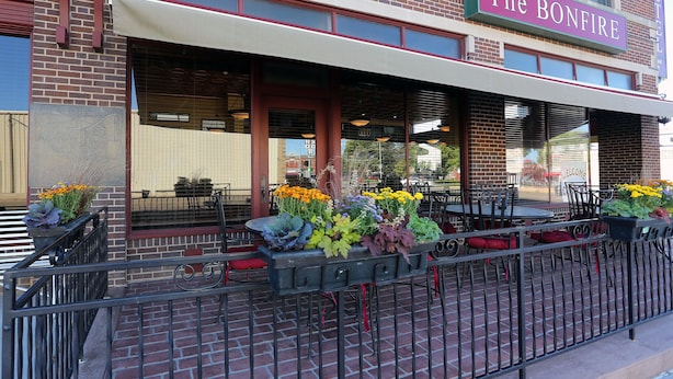 The Bonfire Hotel with outdoor seating and flower arrangements. - Arrow Hotel (Broken Bow)