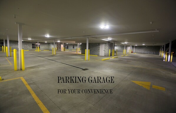 A parking garage with multiple levels and yellow bollards. - Arrow Hotel (Broken Bow)