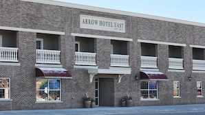 A brick building with a sign reading "Arrow Hotel East." - Arrow Hotel (Broken Bow)