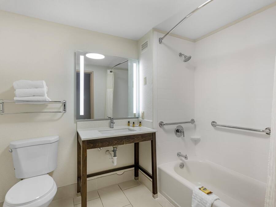 Un baño con inodoro, lavabo, espejo, ducha y bañera.