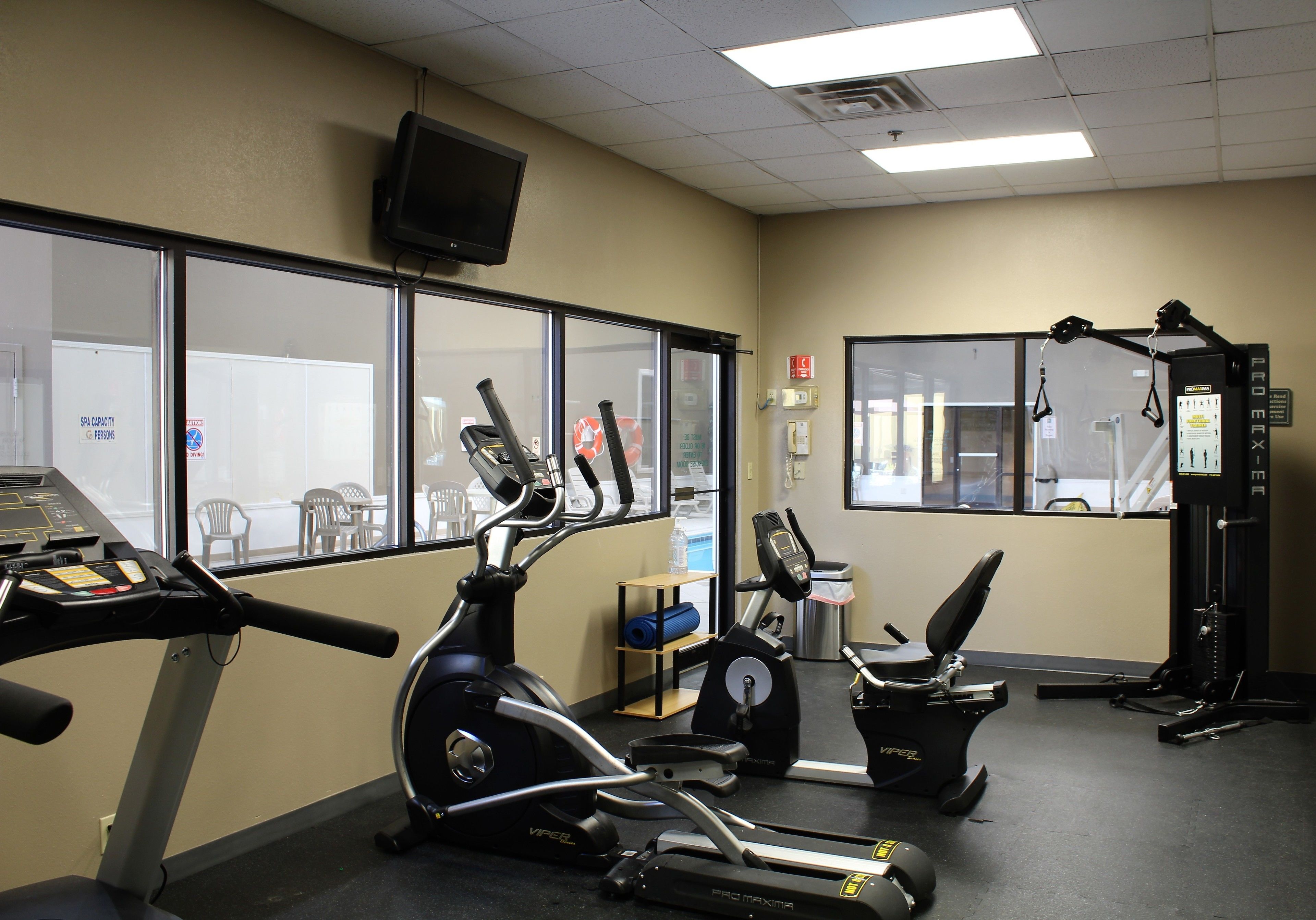 A gym with treadmills, elliptical machines, and a weight machine.
