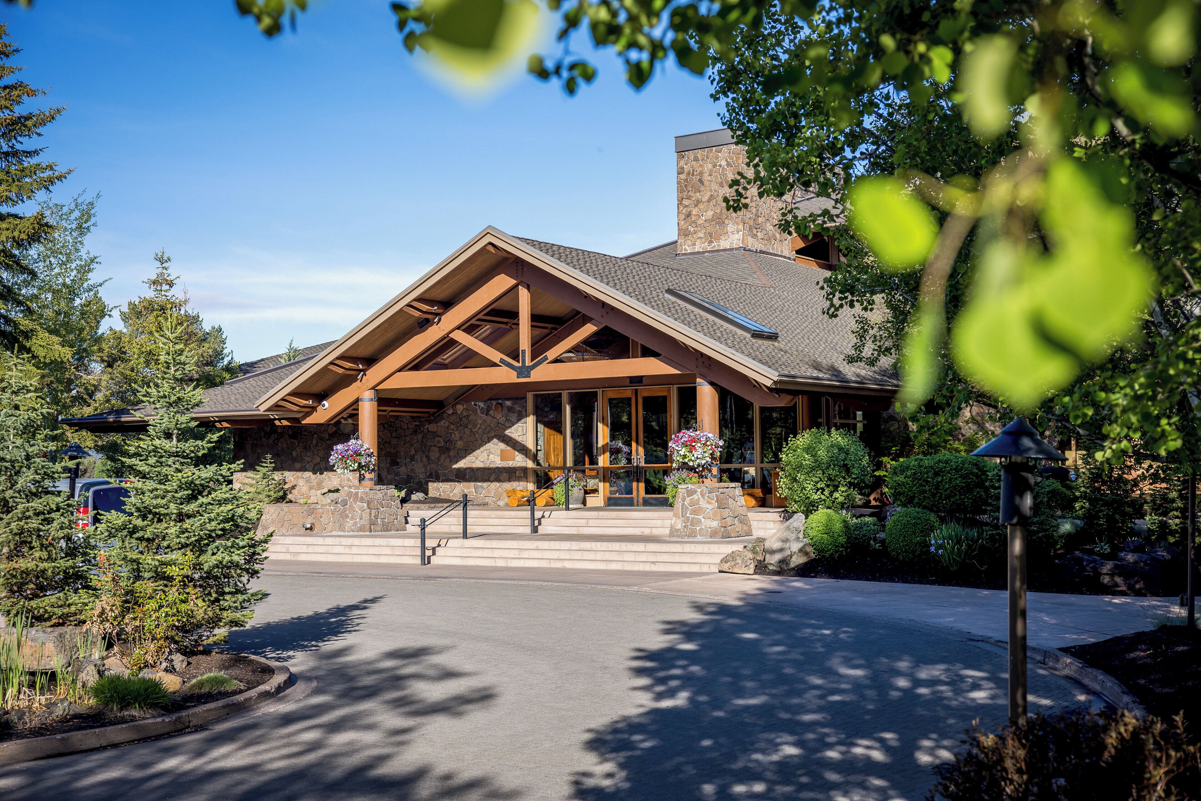A lodge with a stone facade, wooden beams, and a large entrance.