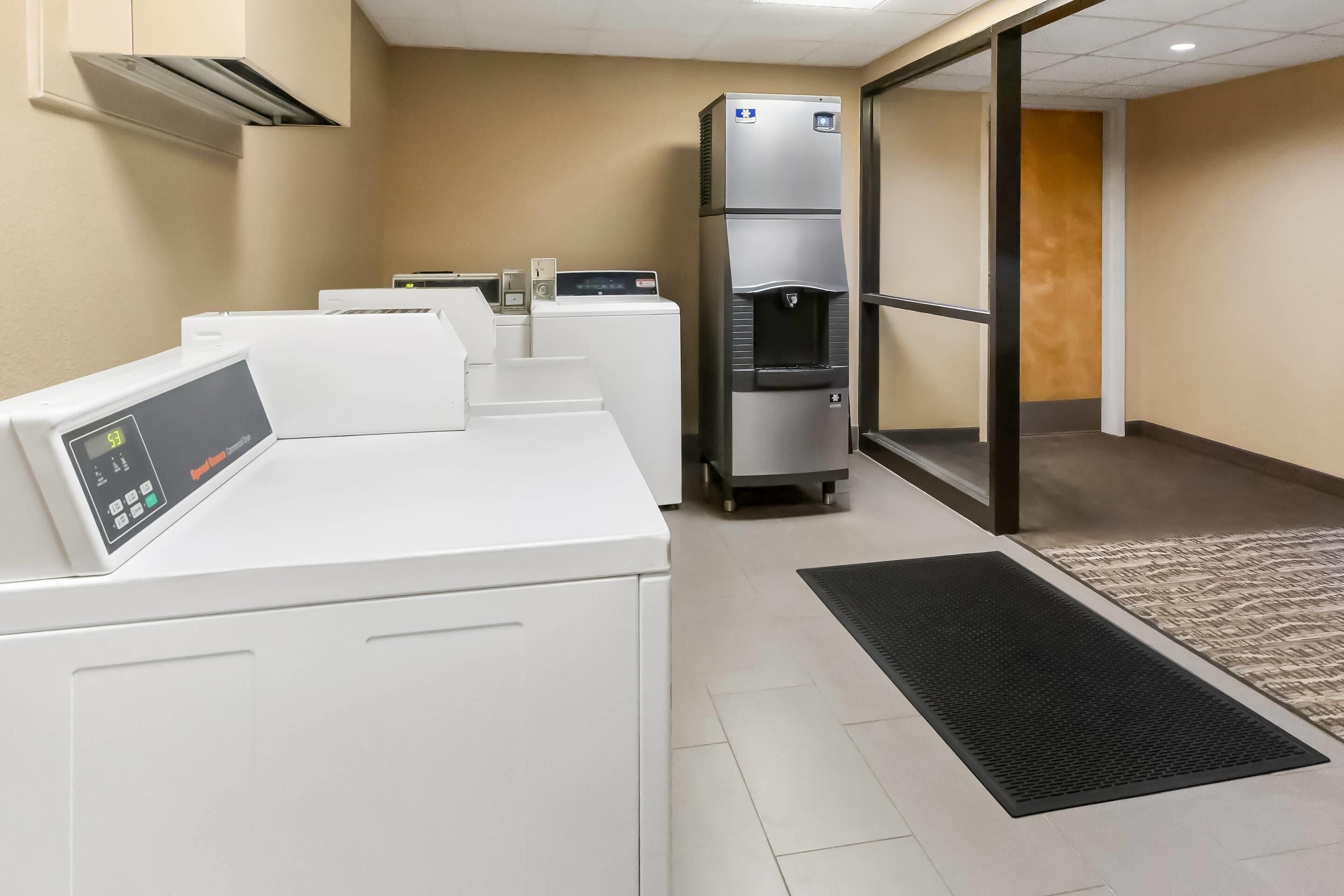 A laundry facility with multiple washing machines and a water dispenser.