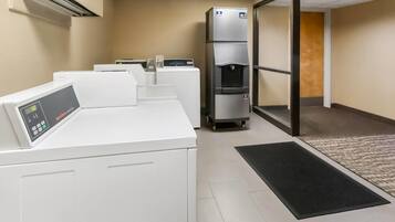 A laundry facility with multiple washing machines and a water dispenser.