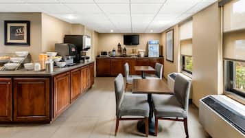 A hotel dining area with a wooden counter, buffet, and seating.