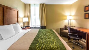 A hotel room with a bed, a desk, a chair, and two lamps. - Quality Inn (Newport News)