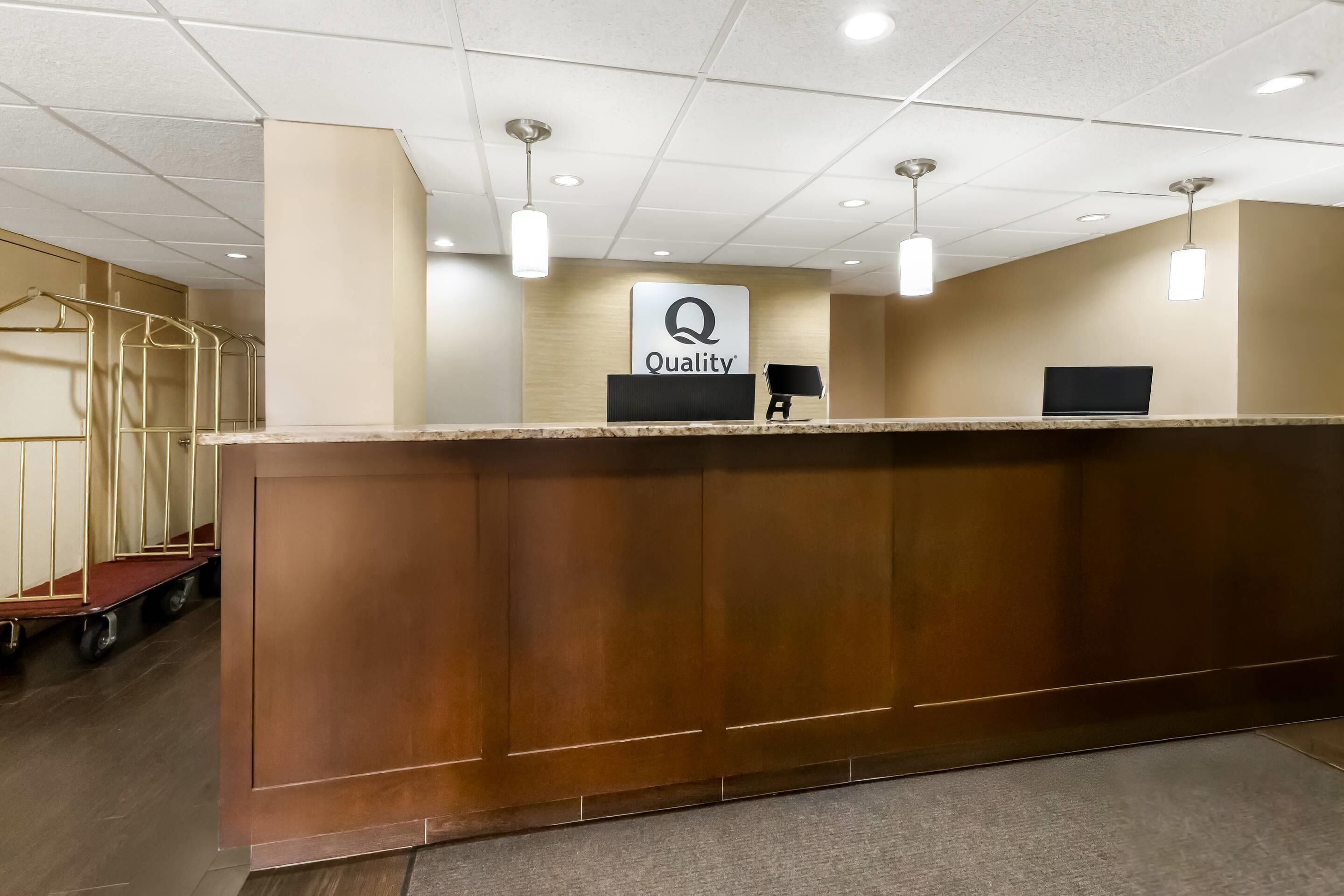 A reception desk with a 'Quality' sign, a computer monitor, and a telephone.