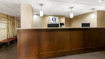 A reception desk with a 'Quality' sign, a computer monitor, and a telephone.