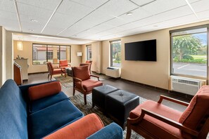 A hotel lobby with seating, a TV, and a view of the outdoors. - Quality Inn (Newport News)