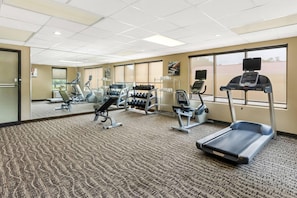 A gym with cardio machines, weight stations, and mirrors. - Quality Inn (Newport News)