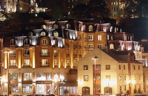 A multi-story hotel with illuminated balconies and a prominent entrance. - Auberge Saint-Antoine (Québec City)