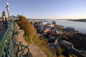 Panoramic city view with a river and various buildings, including historic and modern structures.