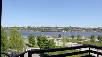 A view of a waterfront area with a clear sky, a river, and a distant cityscape.