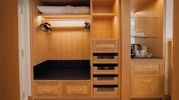 Een compacte slaapkamer met een stapelbed, inbouwopslag en een kleine kitchenette.