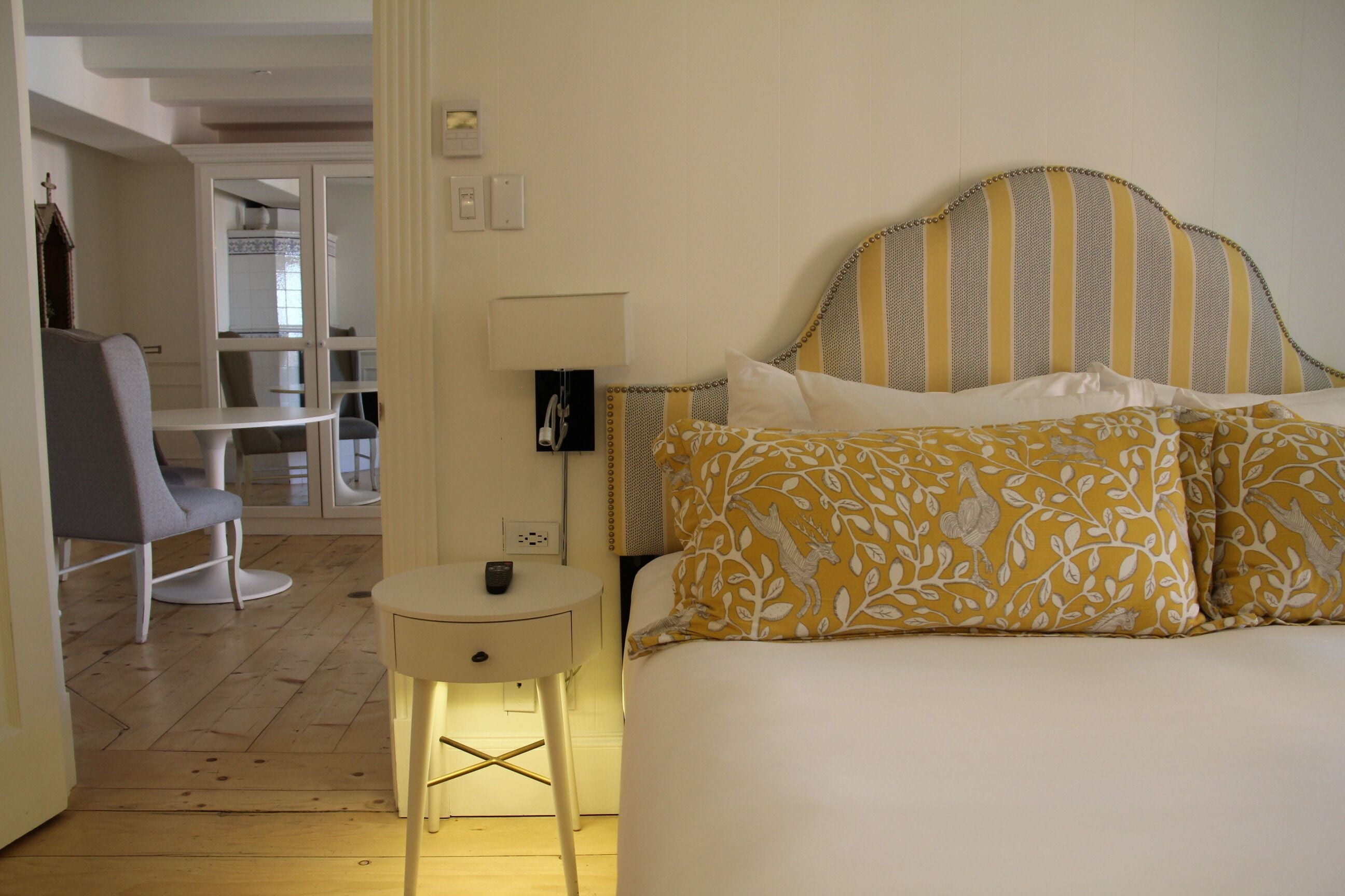 A bedroom with a bed, bedside table, and a chair.