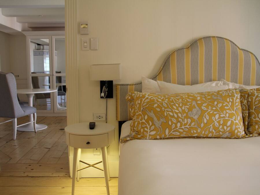 A bedroom with a bed, bedside table, and a chair.