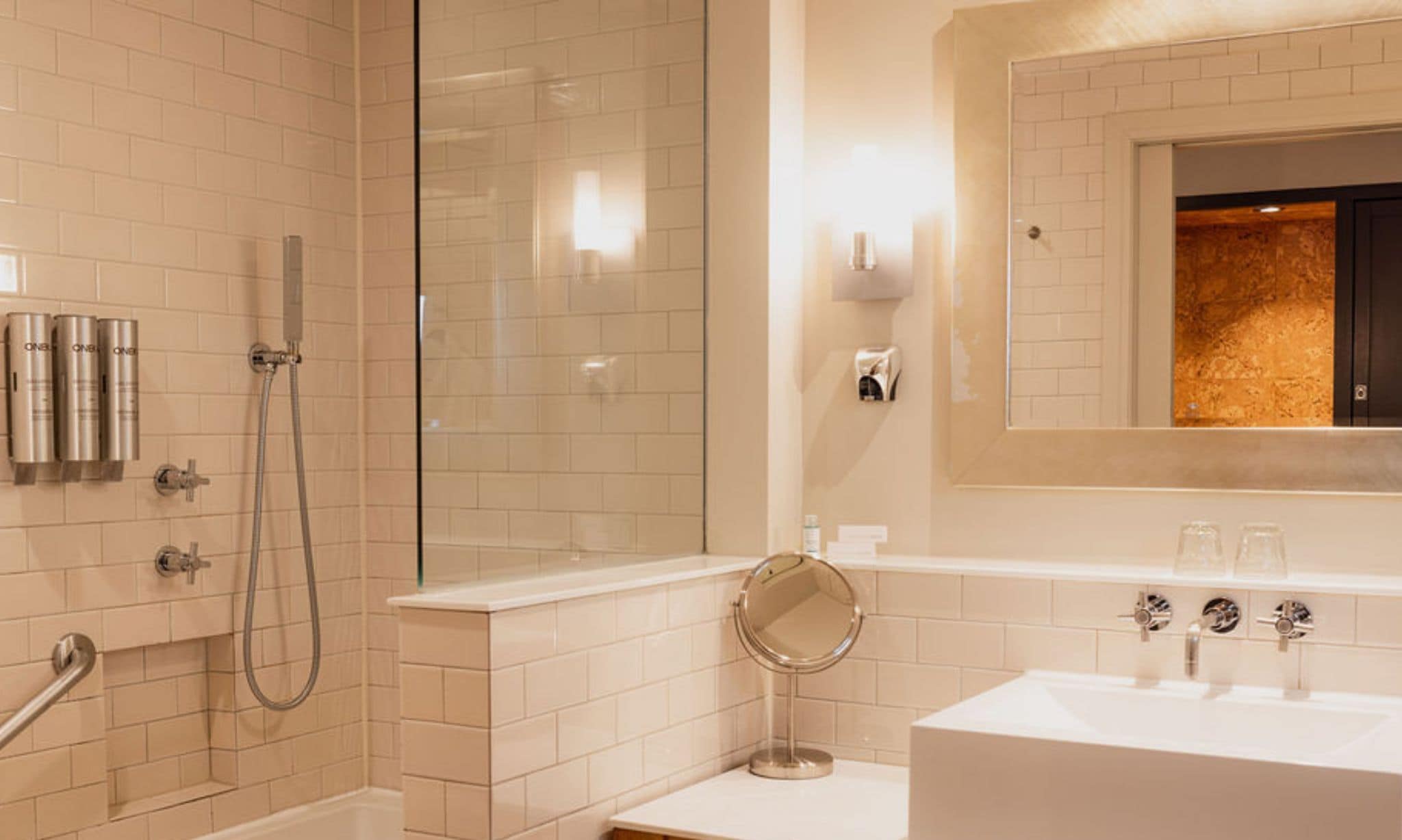 Une salle de bain d’hôtel équipée d’une douche, d’une baignoire, d’un lavabo et d’un miroir.