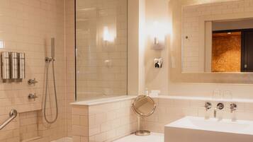 Une salle de bain d’hôtel équipée d’une douche, d’une baignoire, d’un lavabo et d’un miroir.