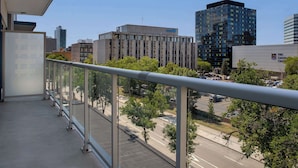 A balcony with a view of a cityscape, including a parking lot and buildings with signage. - Hampton Inn by Hilton Winnipeg Downtown (Winnipeg)