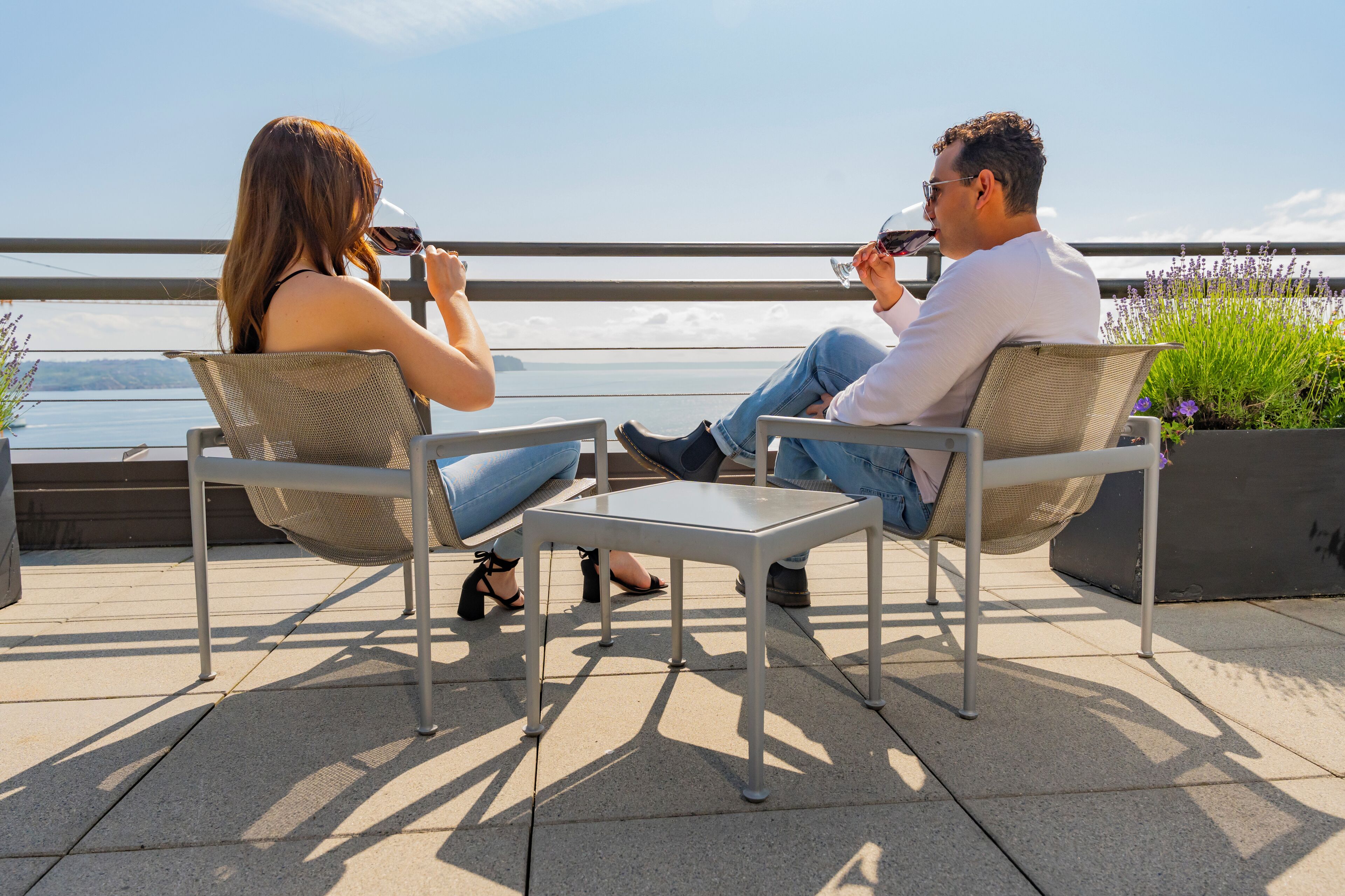 Dos personas sentadas en una terraza con vistas al agua.
