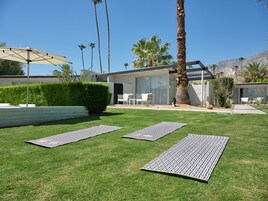 Una casa moderna con patio, pergola, area relax esterna e prato curato.